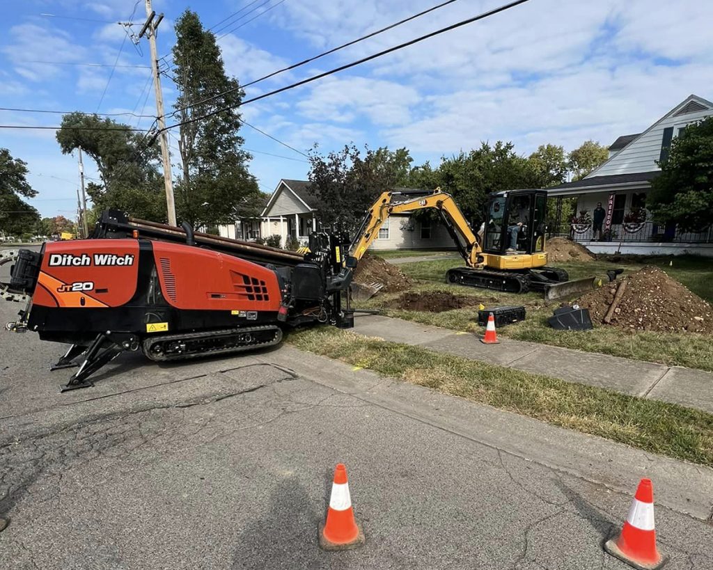 A photo of a directional boring machine and a mini excavator being used to install new gas and water lines in Dayton, Ohio.